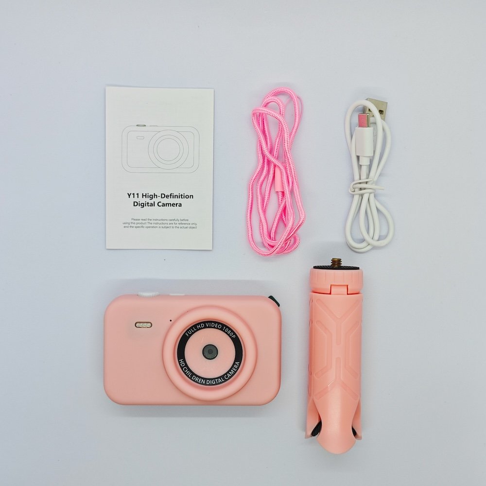Wholesale Y1 high-definition kids camera set including pink digital camera, tripod stand, lanyard, and USB charging cable.