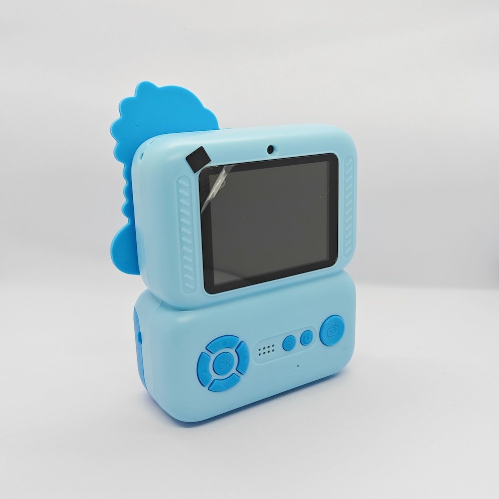 Blue kids print camera with Dinosaur decorative attachment, integrated rear screen and easy-control buttons, compliant with safety standards.