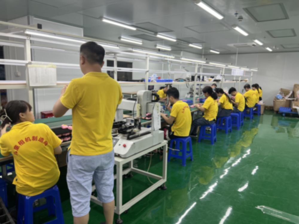 Production line with some workers in yellow T-shirts.