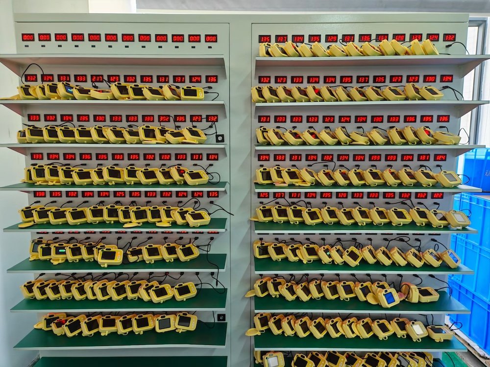 A mass aging test station for kids digital cameras to ensure battery and screen stability before packaging.